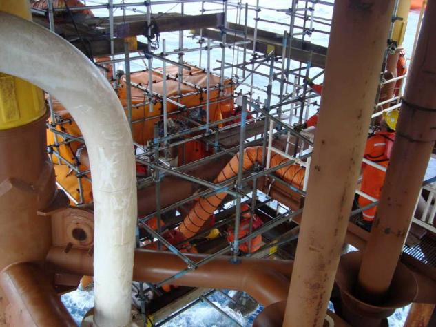 Worker installing welding enclosure system on offshore platform