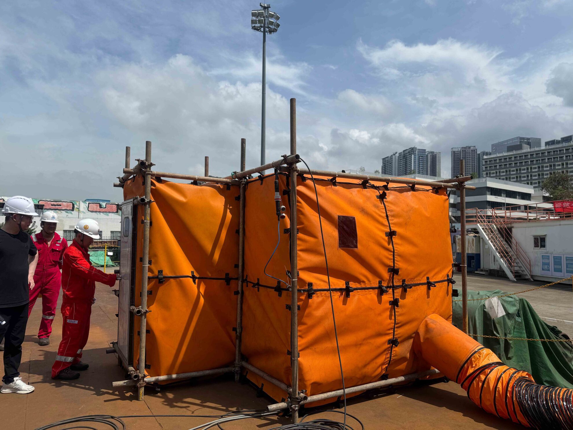 Worker inspecting welding enclosure equipment to ensure safety and proper operation