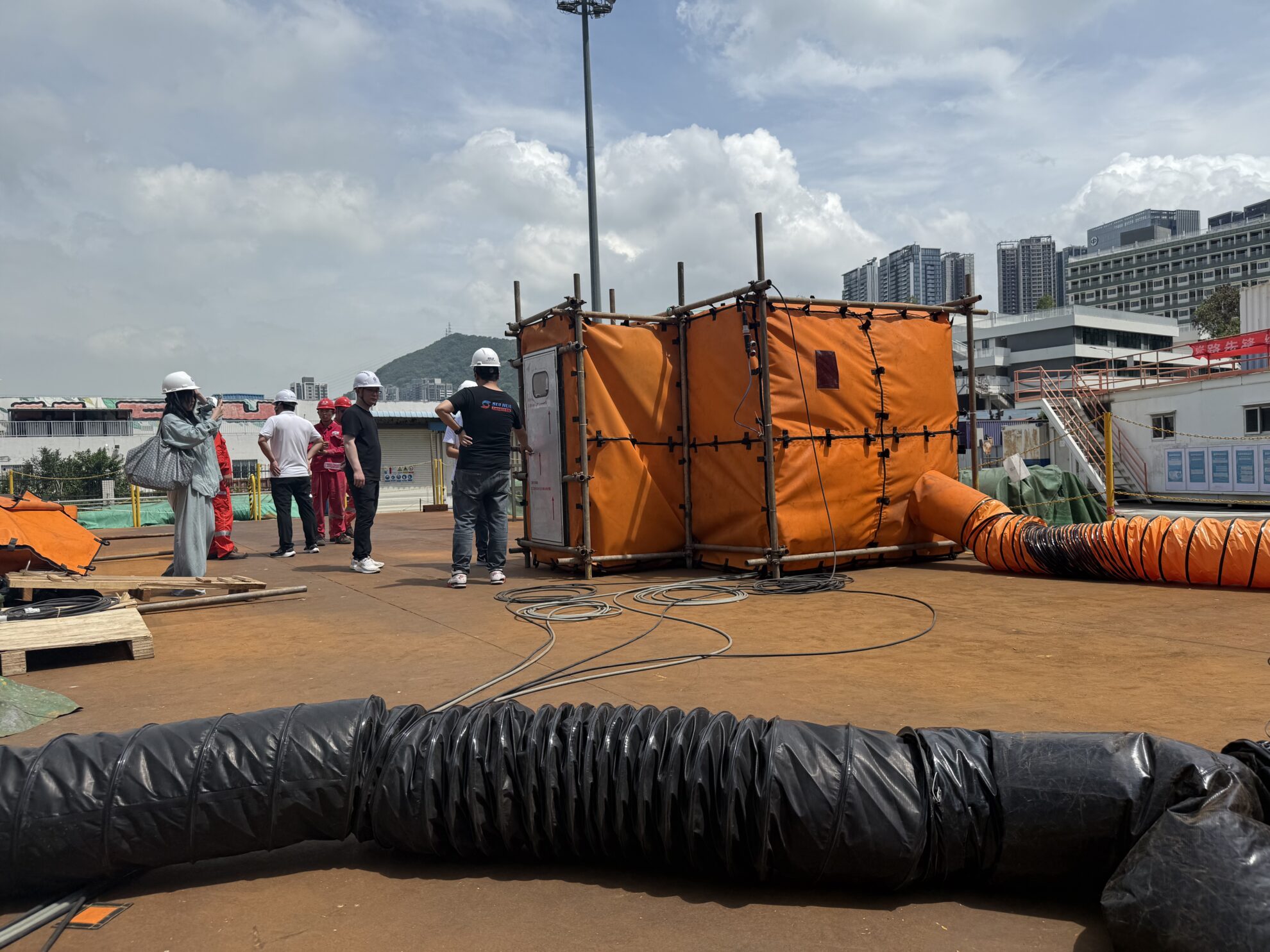 Technician guiding workers installing a welding habitat system on site